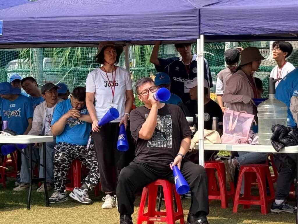第一次參與棒球營的高湯華斌牧師，在場邊拿著加油筒大聲替孩子們應援，也在陪伴與歡呼中，被孩子們的勇敢深深感動。